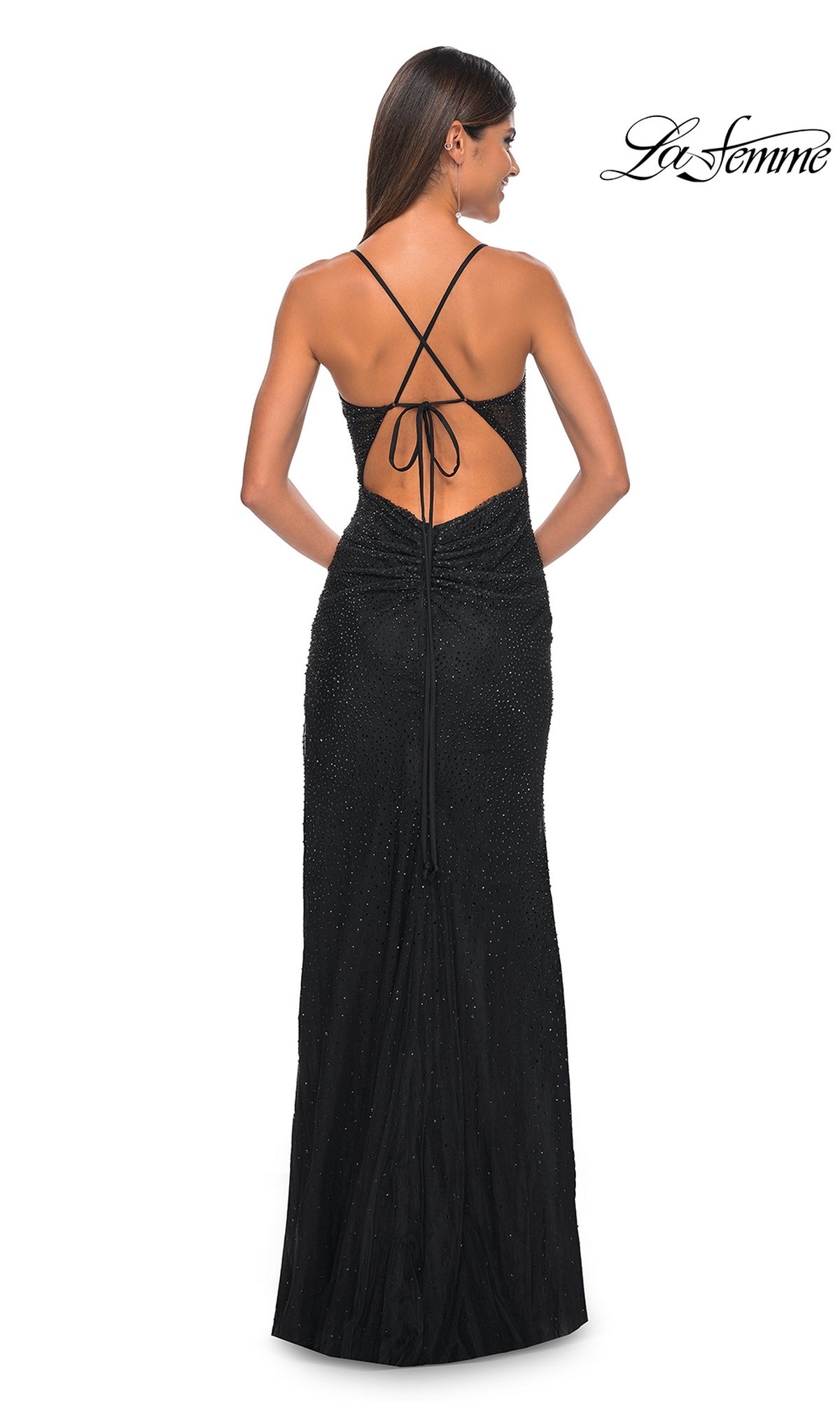 A woman faces away, wearing the La Femme Sheer-Corset Long Beaded Prom Dress 31701 with crisscross spaghetti straps and subtle embellishments. The La Femme logo appears in the top right corner.